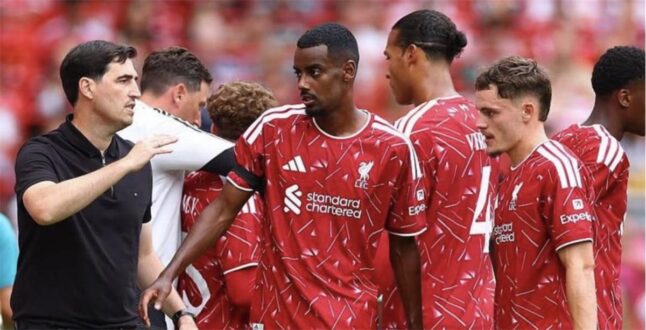 لاعب كرة قدم يرتدي قميص ليفربول يتحدث مع مدربه