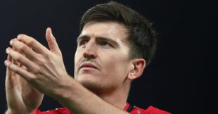لاعب كرة قدم يرتدي قميص مانشستر يونايتد مع علامة X فوقه
