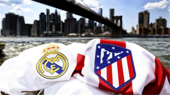 لاعبو ريال مدريد وأتلتيكو مدريد يتنافسون على الكرة في الملعب
